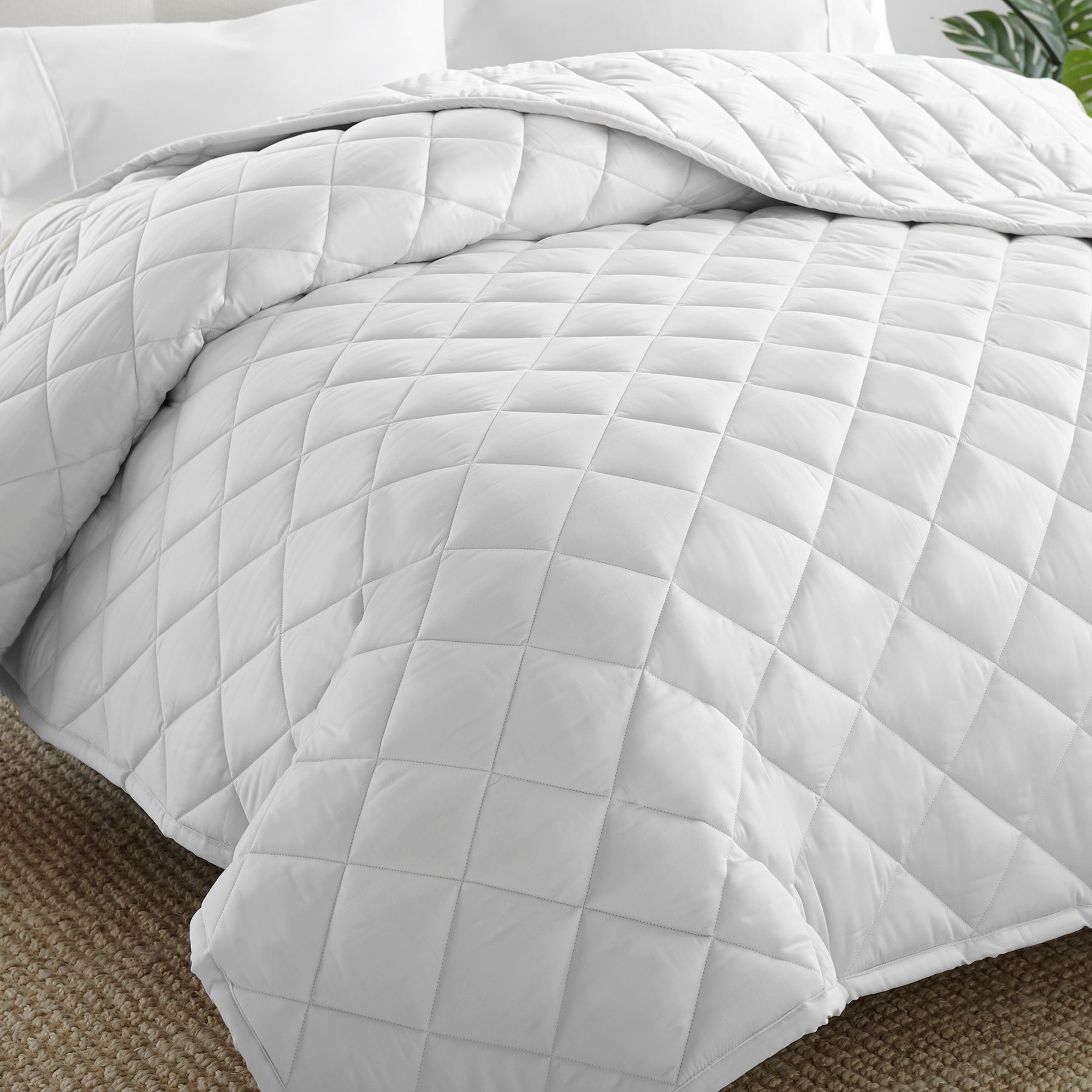Whisper organics GOTS and fairtrade certified diamond stitch square white comforter laid out on bed