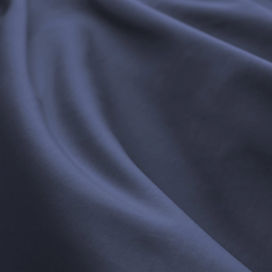 Close-up of navy sateen cotton fabric showing its soft folds and drape.