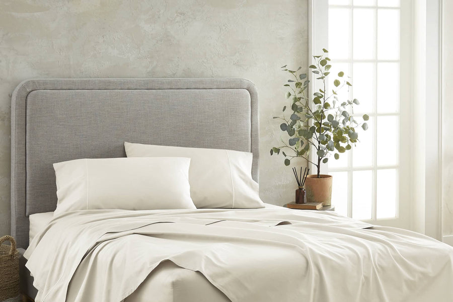 Sateen cotton sheet set styled on a bed in ivory.