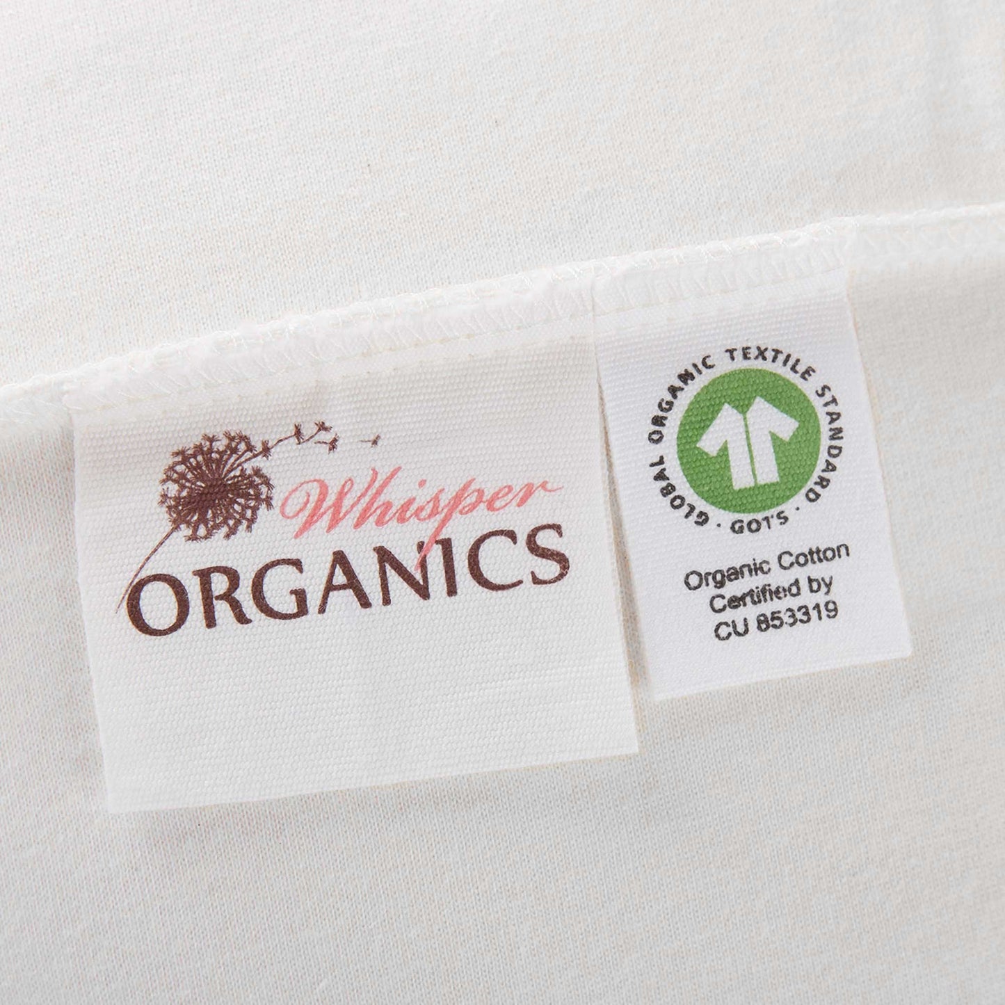 Close-up of tags on mattress pad showing GOTS certification alongside Whisper Organics logo. 
